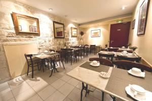 a dining room with tables and chairs in a restaurant at Hotel William's Opera in Paris