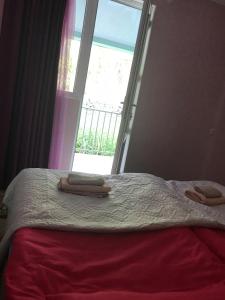 a bed with two towels on it in front of a window at Riverside Kazbegi in Stepantsminda