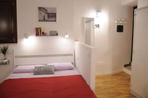 una piccola camera con un letto con una coperta rossa di Argo's Apartment a Palermo