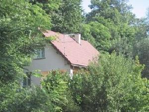 a house with a red roof in the trees at 77 Rue de la Bresse in Nance