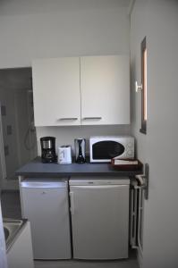 a kitchen with white cabinets and a black counter top at Amido Zen in Toulouse