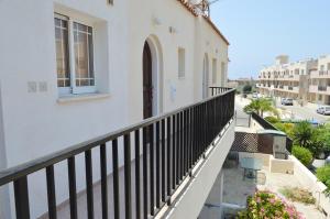 ein Balkon eines weißen Gebäudes mit einem Fenster in der Unterkunft Apartment in Kato Pafos & 10 min to Venus beach in Paphos City + 6 Fotos