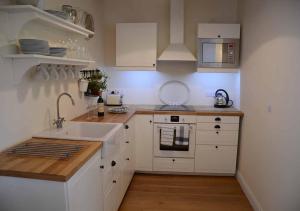 a white kitchen with a sink and a stove at Raleigh Barn in West Putford