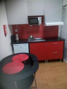 una pequeña cocina con mesa y microondas en Metro-Apartment RNAL nº35375 AL-Chamada para a rede móvel nacional, en Oporto
