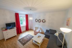 a living room with a couch and a tv at Gästehaus Elfriede in Mörbisch am See