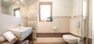a white bathroom with a sink and a toilet at Niederhof life in Lana +9 photos