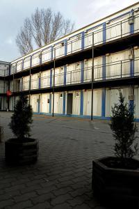 a large building with two trees in front of it at Hostel Metro in Warsaw