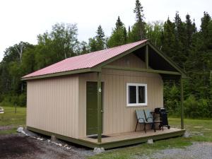 a small shed with a chair in a yard at WildExodus Outdoors in Timmins