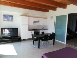 eine Küche und ein Esszimmer mit einem schwarzen Tisch und Stühlen in der Unterkunft Villa Belvedere Degli Ulivi in Osimo