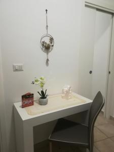 una mesa blanca con una silla negra y una lámpara en Elisea House, en Oria