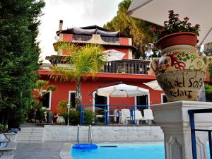 une piscine avec un grand vase à côté d'un bâtiment dans l'établissement B&B Villa del Sole Relais, à Agrigente