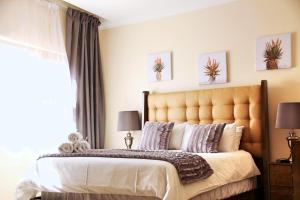 una camera da letto con un grande letto con una grande finestra di Green Haven Luxury Apartments a Ezulwini