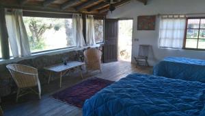 a bedroom with a bed and a table and chairs at La Tahona in Rocha