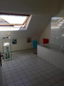 Au Nid de Tillé في Tillé: حمام علوي مع حوض استحمام ونور