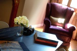 una mesa con un jarrón de flores y un libro en Residence La Fenice en Venecia