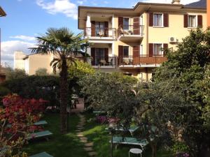 a building with a palm tree in front of it at Hotel Erika in Malcesine