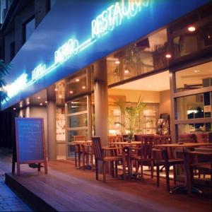 a restaurant with wooden tables and chairs in front of it at Hotel De Croone in Ninove