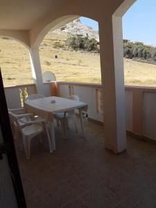 un tavolo e sedie su un balcone con vista su un campo di Apartments Denis a Metajna