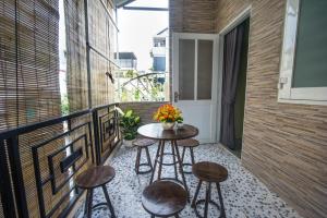 a balcony with a table and stools at Language Exchange Hostel 1 in Ho Chi Minh City
