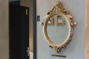 uno specchio su un muro con una cornice d'oro di Engine rooms a Fiume (Rijeka)