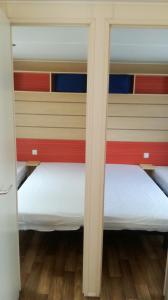 twee bedden in een kamer met rode en gele muren bij Camping Chantecler in Luchon