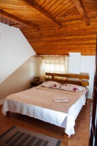 a bedroom with a large bed with a wooden ceiling at Rustic Argesean in Corbeni