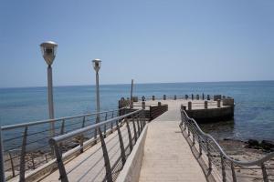 a pier with benches and lights on the water at Casa Gaia in Avola