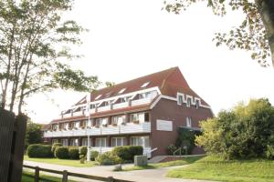 ein großes rotes Backsteingebäude mit weißer Ausstattung in der Unterkunft Hotel Spiekeroog in Spiekeroog