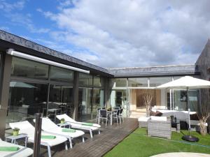 een terras met witte stoelen en tafels in een huis bij Opal Villa de Luxe in La Playa de Tauro