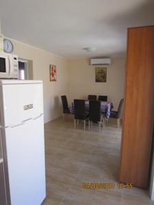 a kitchen and dining room with a white refrigerator at Villa Helen in Donji Stoliv