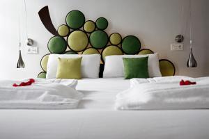 Un dormitorio con una cama blanca con almohadas verdes y blancas en Pensión Basque Boutique, en Bilbao