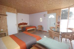 - une chambre avec deux lits, une table et un lit dans l'établissement Hotel Rose, à Beauvoir