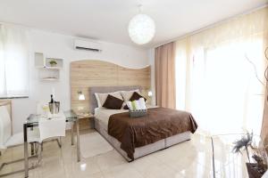 Apartments Maritea في فوديس: غرفة نوم بسرير وطاولة ومكتب