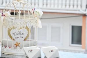 una torta bianca con una gabbia per uccelli con un cuore di Apartments Maritea a Vodice