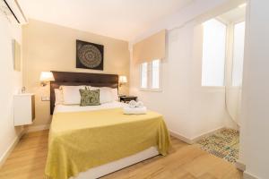 1 dormitorio con 1 cama grande con manta amarilla en Soho Puerto, en Málaga