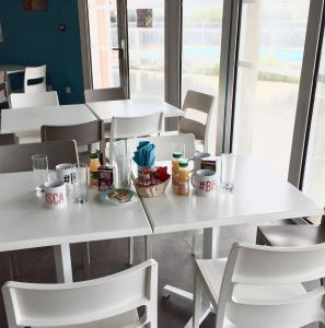 比斯卡羅斯海灘的住宿－Maison Indigo 6 personnes，一张白色的桌子和椅子,上面有食物