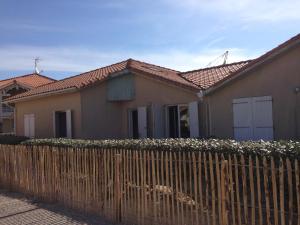 una casa con una valla delante en Maison Indigo 4 personnes, en Biscarrosse-Plage