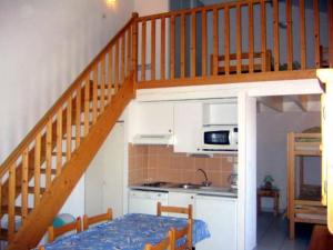 比斯卡羅斯海灘的住宿－Maison Indigo 6 personnes，一间带楼梯的厨房和一间带桌子的厨房