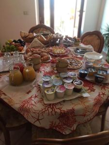B&B Il Corallo في لا ماداّلينا: طاولة مليئة بالطعام فوق طاولة