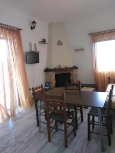 a living room with a table and chairs and a fireplace at Marietta's Apartments in Agios Andreas
