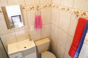 a bathroom with a toilet and a sink and a mirror at Pousada Namastê in São Thomé das Letras