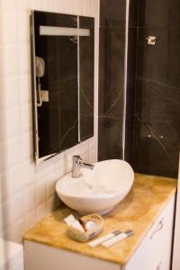 y baño con lavabo blanco y espejo. en Hotel Turizem Shkelzeni, en Kolgecaj