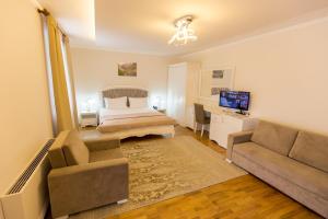 a bedroom with a bed and a couch and a television at Hotel Turizem Shkelzeni in Kolgecaj +50 photos