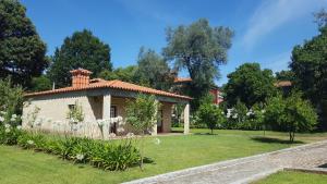ein Haus in einem Garten mit weißen Blumen in der Unterkunft Quinta Vale do Homem in Amares