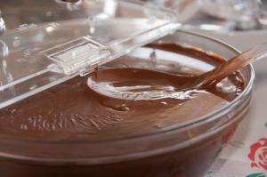 a plastic container of chocolate pudding with a spoon in it at Riviera Perdika Hotel in Perdika