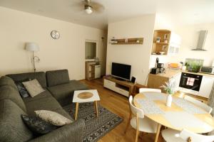uma sala de estar com um sofá e uma mesa em Akord Apartment Centrum em Pärnu