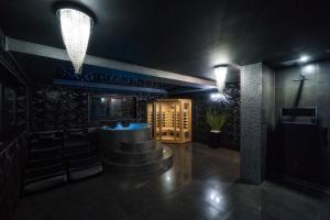 Cette chambre sombre dispose d'un bar avec des chaises et des lumières. dans l'établissement Domek w górach DeLuxe sauna,jacuzzi,basen,hot tub-Nowy Targ blisko Białka ,Zakopane, à Nowy Targ