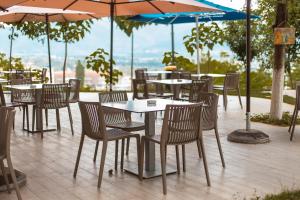 een groep tafels en stoelen met parasols bij Hotel Turizem Shkelzeni in Kolgecaj