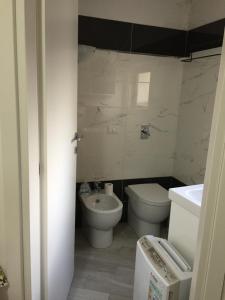 bagno bianco con servizi igienici e lavandino di SoleLuna House a Modica