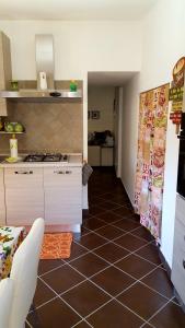 a kitchen with a tiled floor and a kitchen with a stove at SoleLuna House in Modica